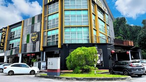 Un hôtel au design moderne, doté de grandes fenêtres et d’une enseigne « HÔTEL » bien visible.