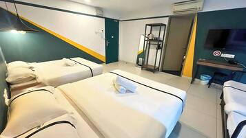 A hotel room with two beds, a TV, a desk, and a gym area.
