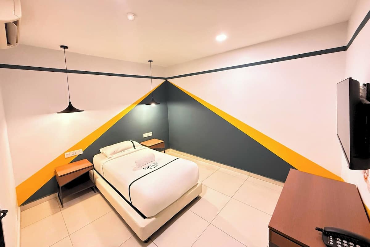 Une chambre moderne avec un lit, une table de chevet et un bureau avec une chaise.