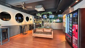 Un intérieur moderne avec un canapé, un coin bar et un distributeur automatique.