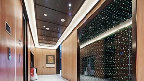 A modern hallway with wooden paneling, a large glass window with a starry night view, and a herringbone-patterned floor. - Orange Hotel (Shanghai Caobao Road Sun Moon Light Center) (Shanghai)
