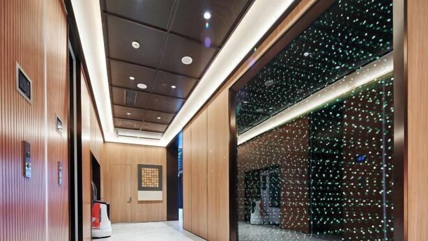 A modern hallway with wooden paneling, a large glass window with a starry night view, and a herringbone-patterned floor. - Orange Hotel (Shanghai Caobao Road Sun Moon Light Center) (Shanghai)