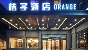 A hotel entrance with a revolving door and illuminated signage. - Orange Hotel (Shanghai Caobao Road Sun Moon Light Center) (Shanghai)
