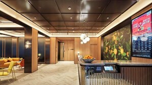 A modern lobby with a reception desk, seating area, and a digital display. - Orange Hotel (Shanghai Caobao Road Sun Moon Light Center) (Shanghai)