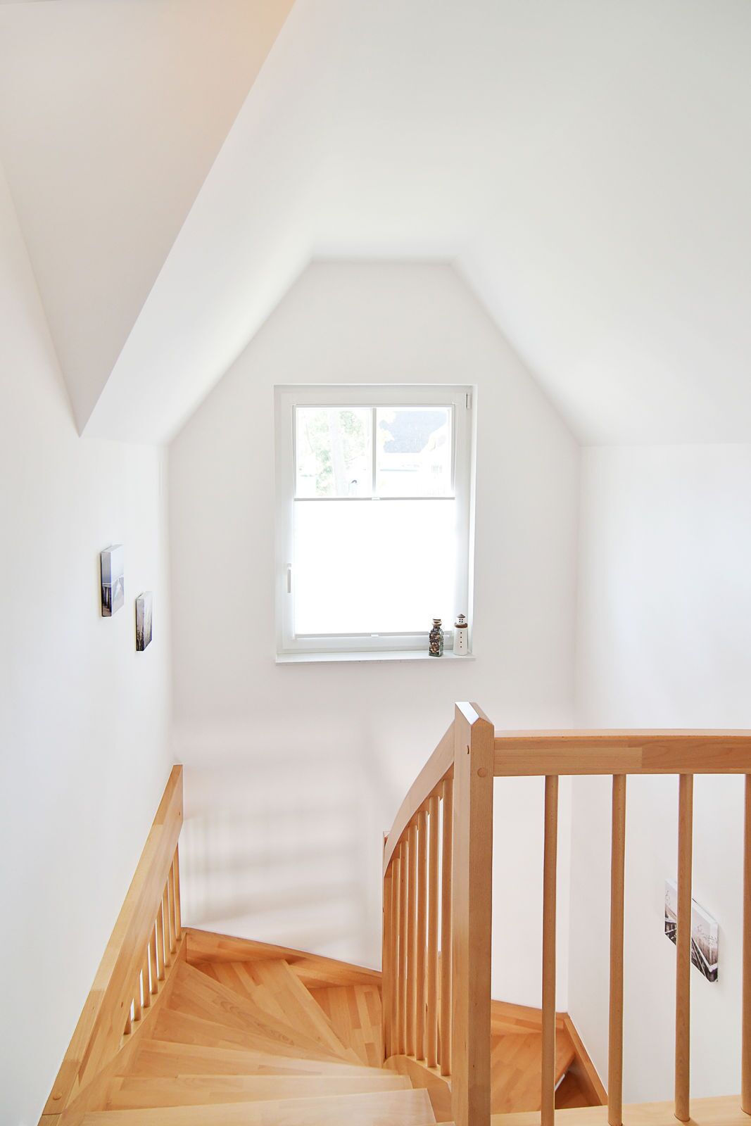 Una escalera con barandillas de madera que lleva a una habitación con ventana.
