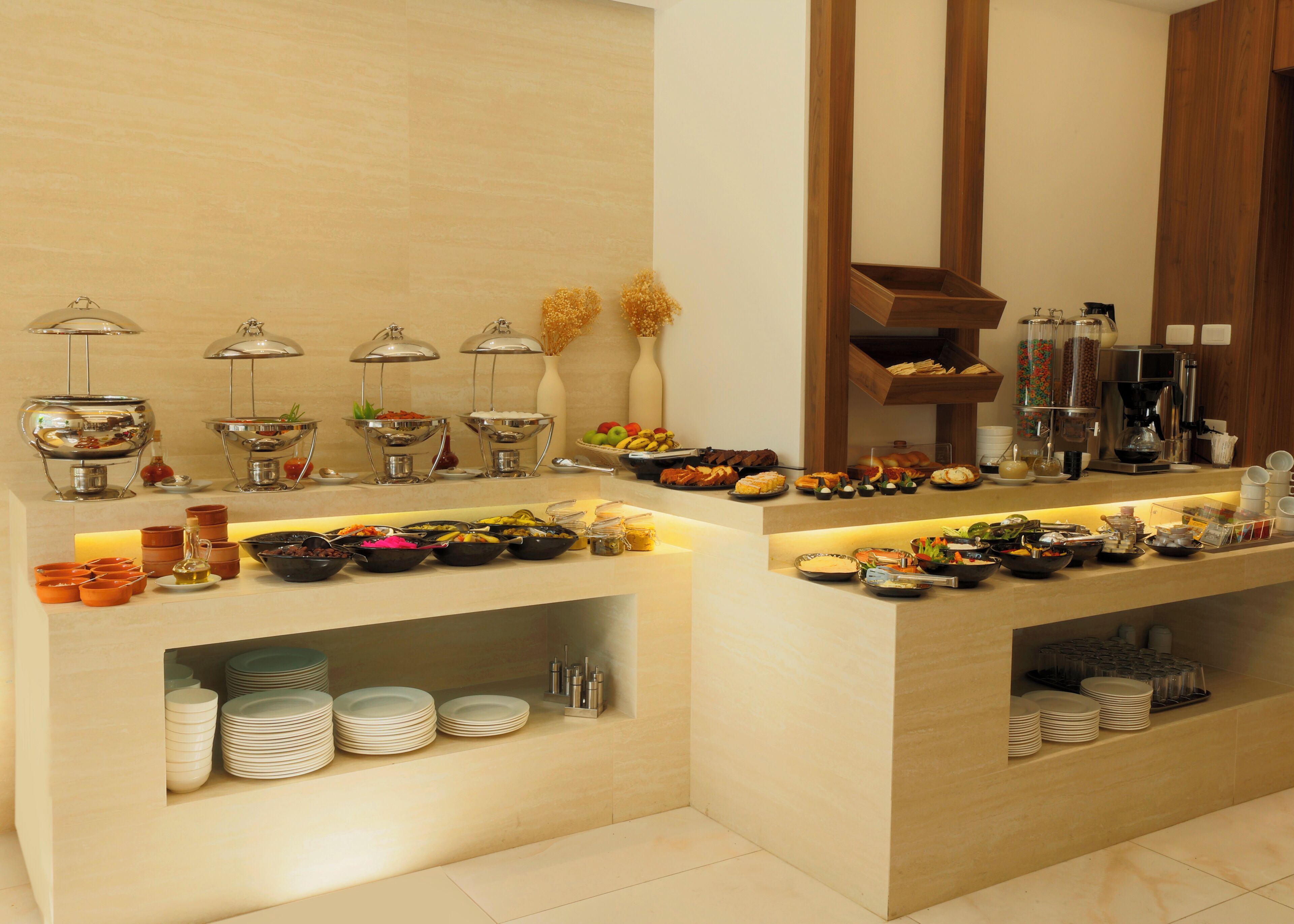 Un buffet proposant une variété de plats et d’ustensiles de service.