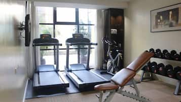 A gym with treadmills, a stationary bike, and a bench.