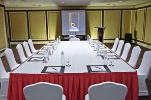 A conference room with a long table, white chairs, and a podium. - B Hotel Alabang (Muntinlupa)