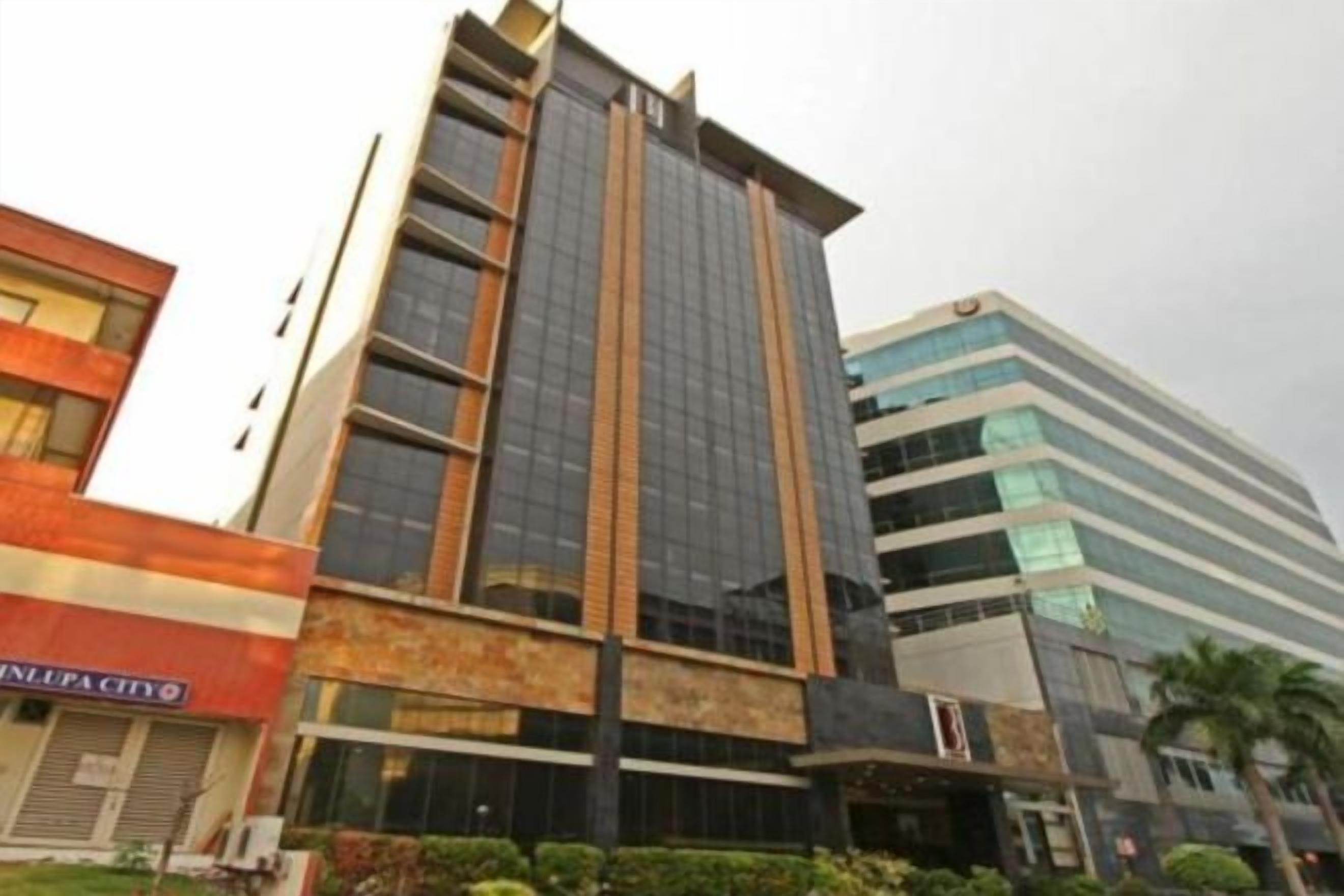A multi-story building with a modern architectural design, featuring a prominent glass facade and a flat roof.
