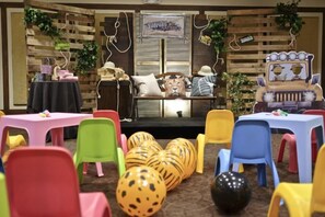 Una habitación con un escenario, sillas coloridas y un sofá.