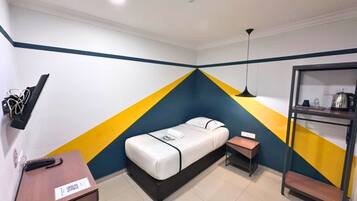 A small, brightly colored room with a bed, a desk, and a shelf with items.