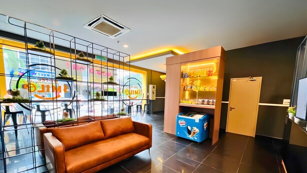 Ein modernes Interieur mit einer Couch, einem Verkaufsautomaten und einer Glastrennwand.