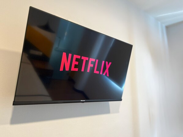A flat-screen TV mounted on a wall displaying the Netflix logo. - Smile Hotel Klang Bukit Tinggi (Klang)