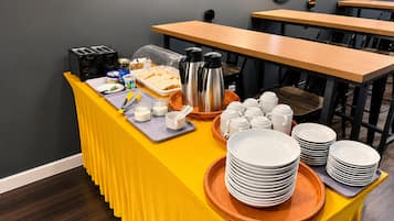 Una mesa de desayuno buffet con diversos alimentos y una estación de café.