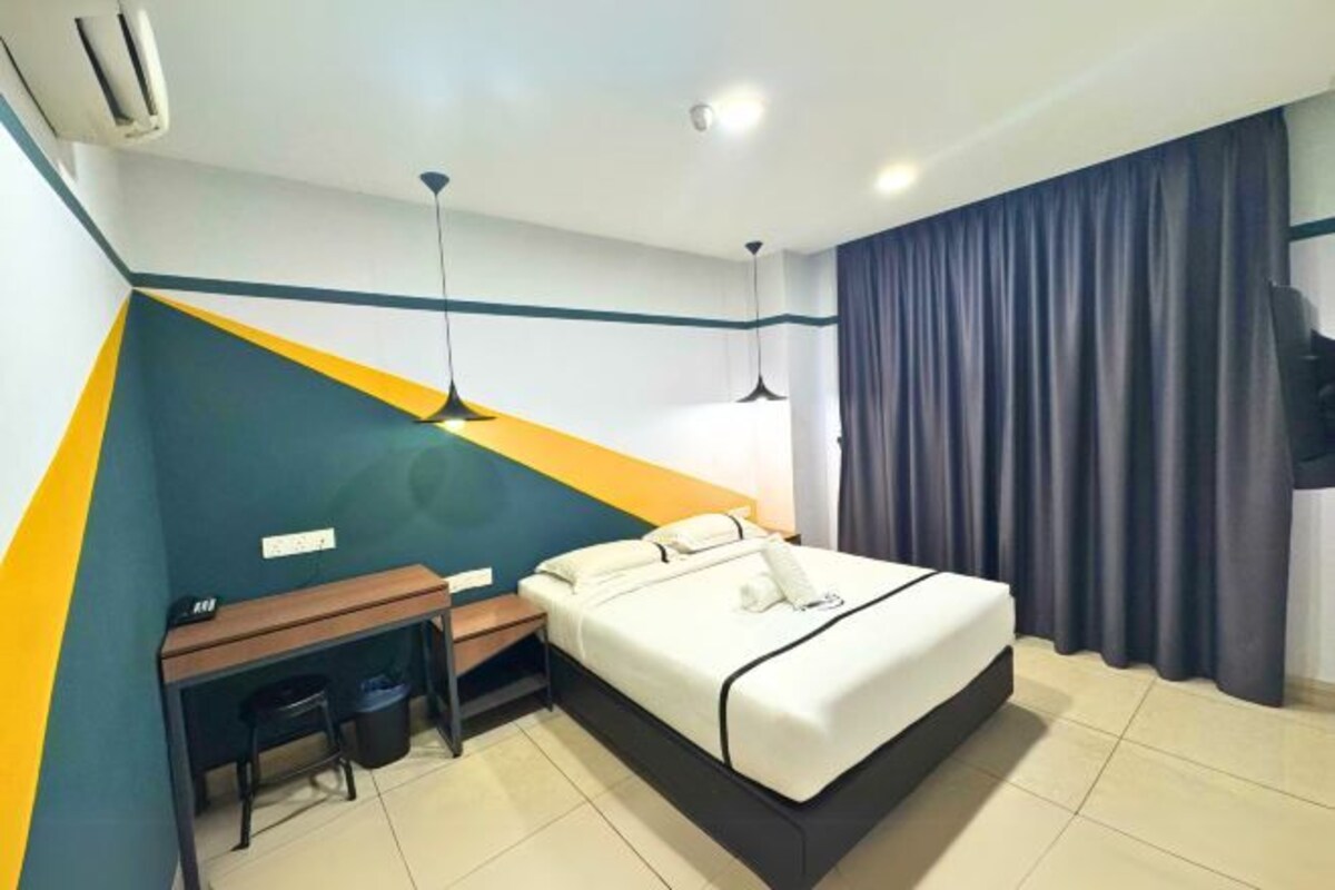 Une chambre d’hôtel équipée d’un lit, d’un bureau, d’une chaise et d’un téléviseur.