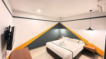 A hotel room with a bed, a desk, a TV, and a wall-mounted heater.