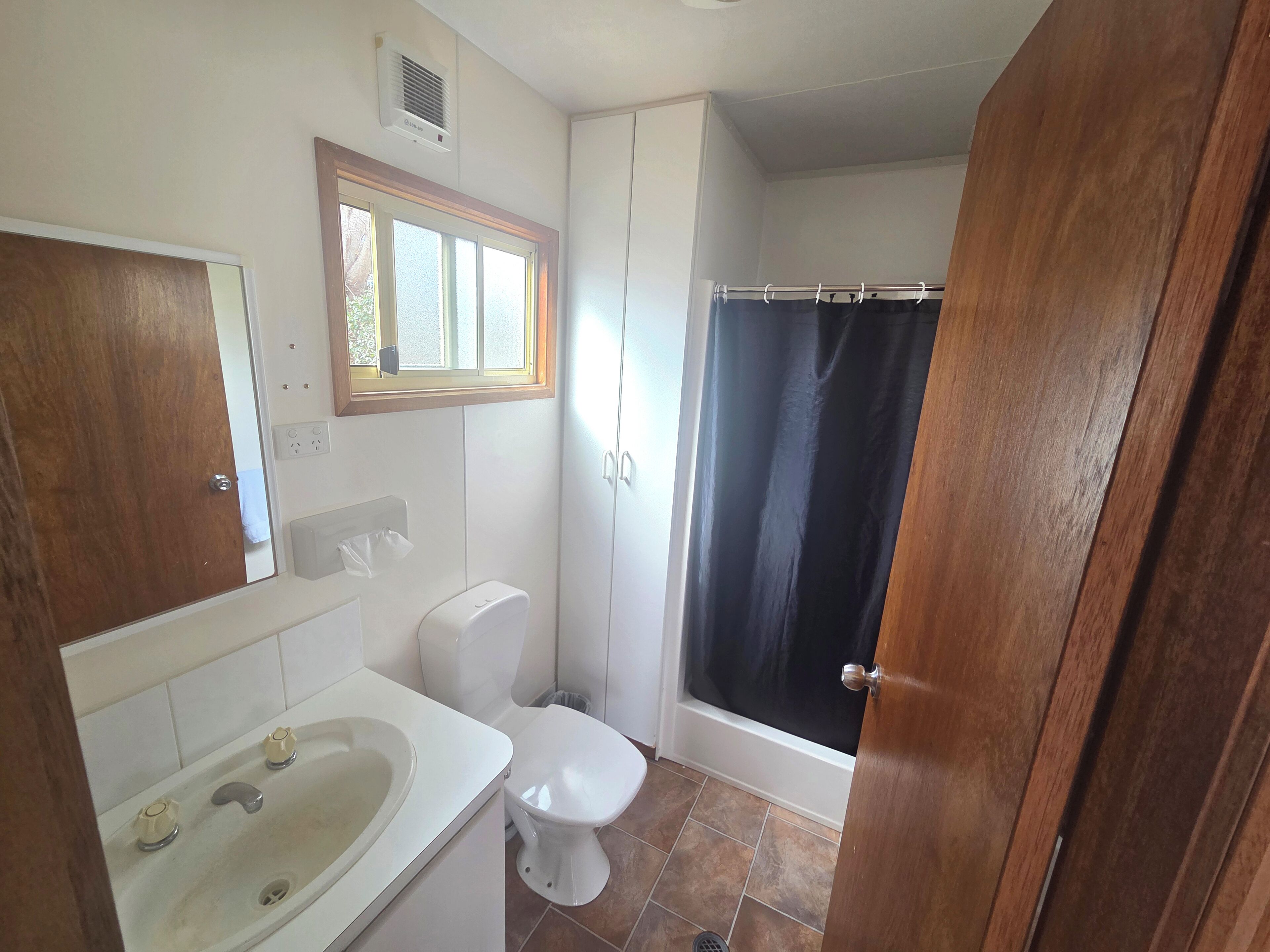 Een badkamer met toilet, wastafel en bad.