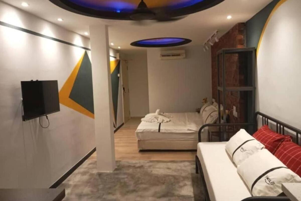 Een moderne hotelkamer met een bed, een televisie en een plafond met ronde verlichtingsarmaturen.