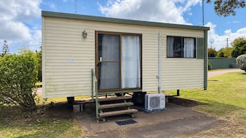 A single-story mobile home with a front door, a small window, and a number '119' on the side.