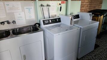 A laundry facility with washing machines and sinks.