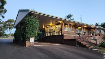 A building with a covered entrance, a staircase, and a sign indicating the number 8.