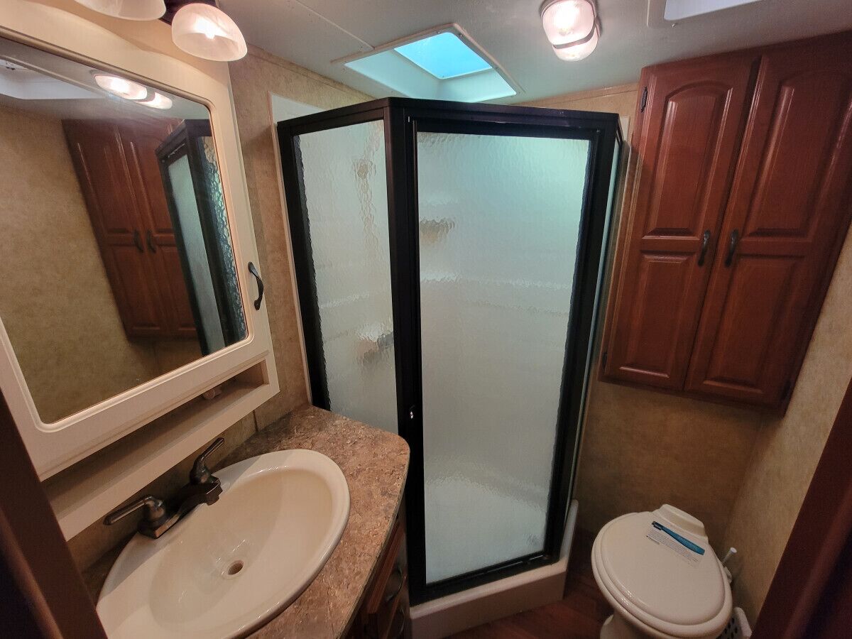Ein kleines Badezimmer mit Waschbecken, Spiegel und Toilette.