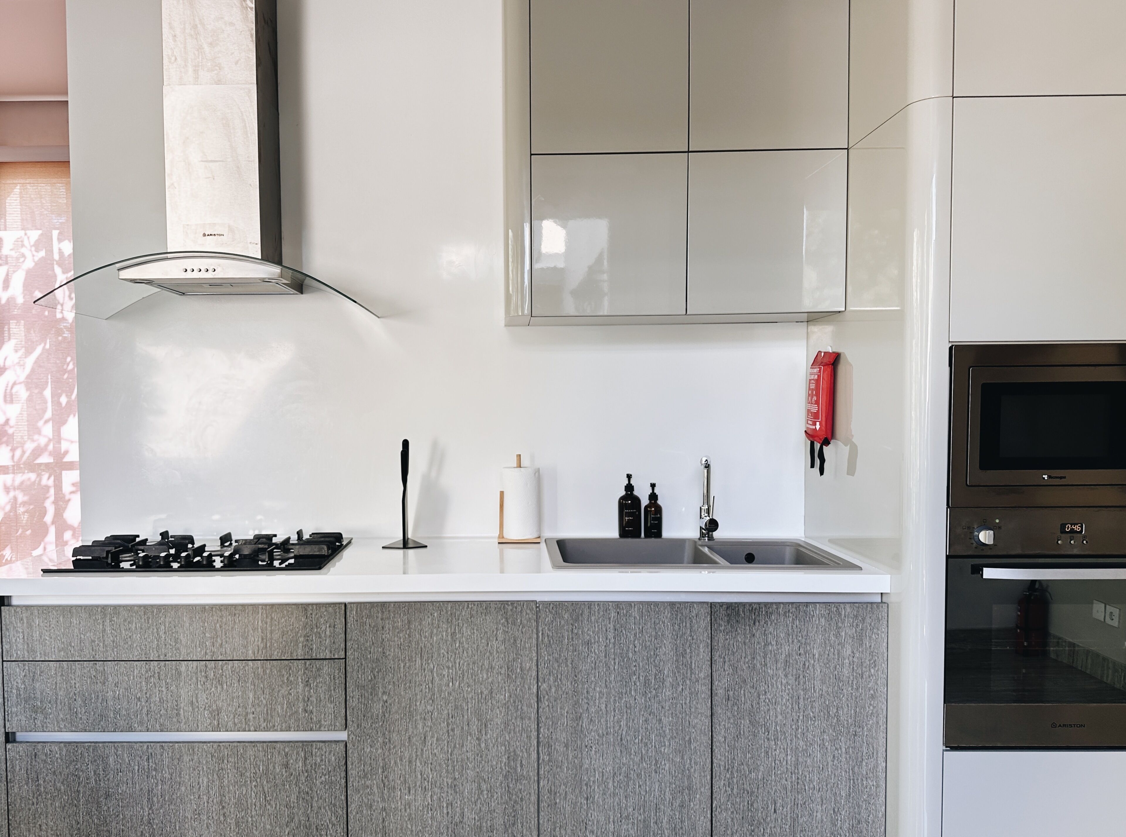 A modern kitchen with a gas stove, stainless steel sink, and a built-in oven.