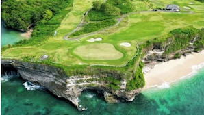 Vista aérea de un campo de golf con una playa y acantilados.