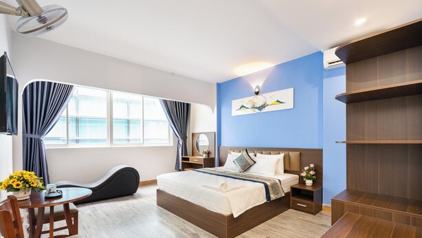 A modern hotel room with a large bed, bedside tables, a desk, and a chair. - Green Airport Hotel (Ho Chi Minh City)