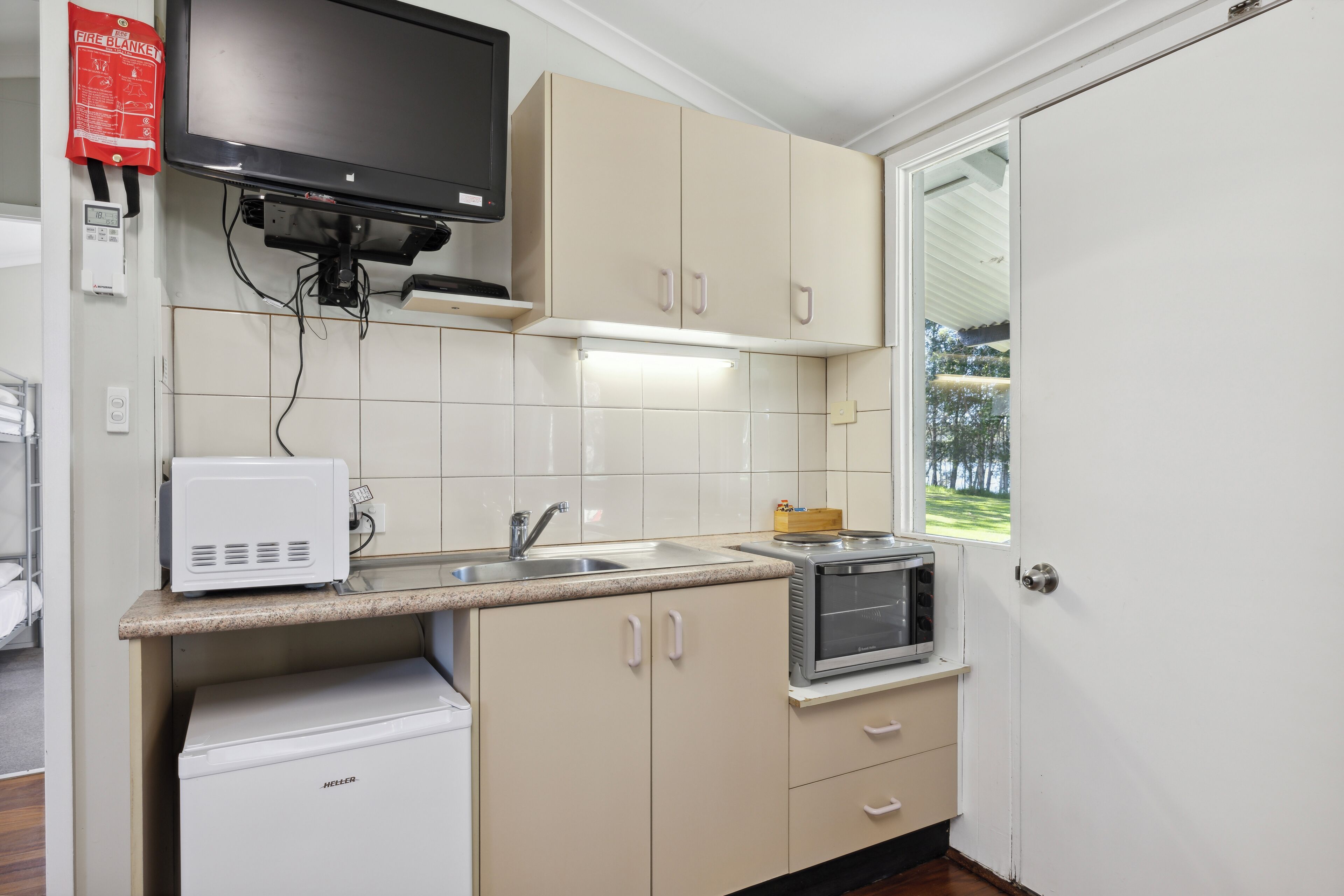 A compact kitchen with a microwave, toaster, and sink.
