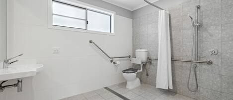 Een moderne badkamer met toilet, wastafel en douche.