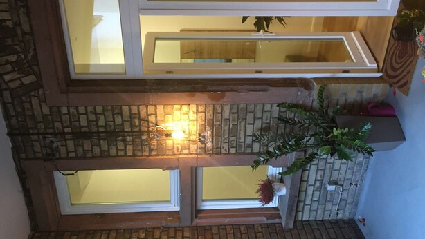 A multi-level interior with a brick wall, a fireplace, and a window overlooking a room. - Perkeo Apartments: 2 Studios with shared terrace | Heidelberg-Oldtown (Heidelberg)