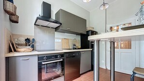 A modern kitchen with stainless steel appliances, a built-in oven, and a range hood. - Charming house in La Ferté-Hauterive, comfort included (La Ferté-Hauterive)