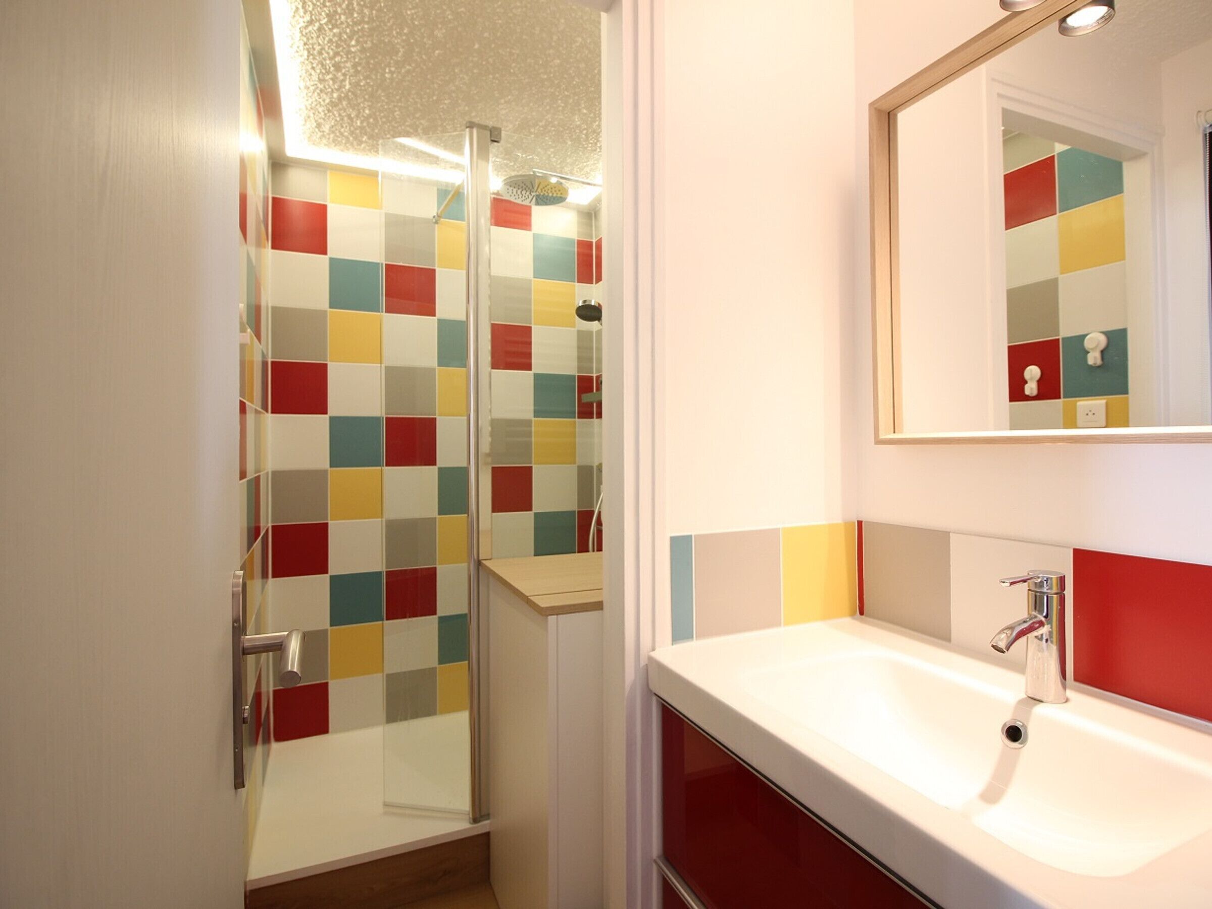 A bathroom with a shower, a sink, and a mirror.