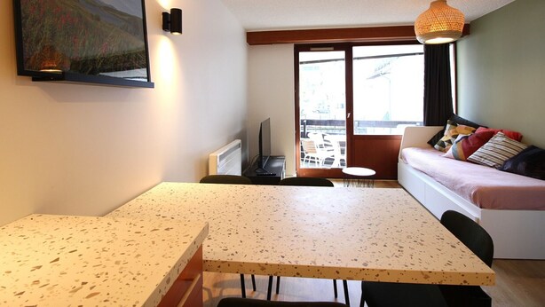 A compact living space with a kitchenette, a dining area, and a sofa with a view. - Beautiful T2 apartment with balcony and parking in Mont-Dore (Mont-Dore)