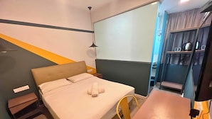 A hotel room with a bed, a desk, a chair, and a wardrobe. - Smile Hotel Subang Airport (Shah Alam)