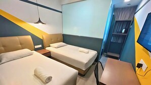 A hotel room with two beds, a desk, a chair, a TV, and a window with curtains. - Smile Hotel Subang Airport (Shah Alam)
