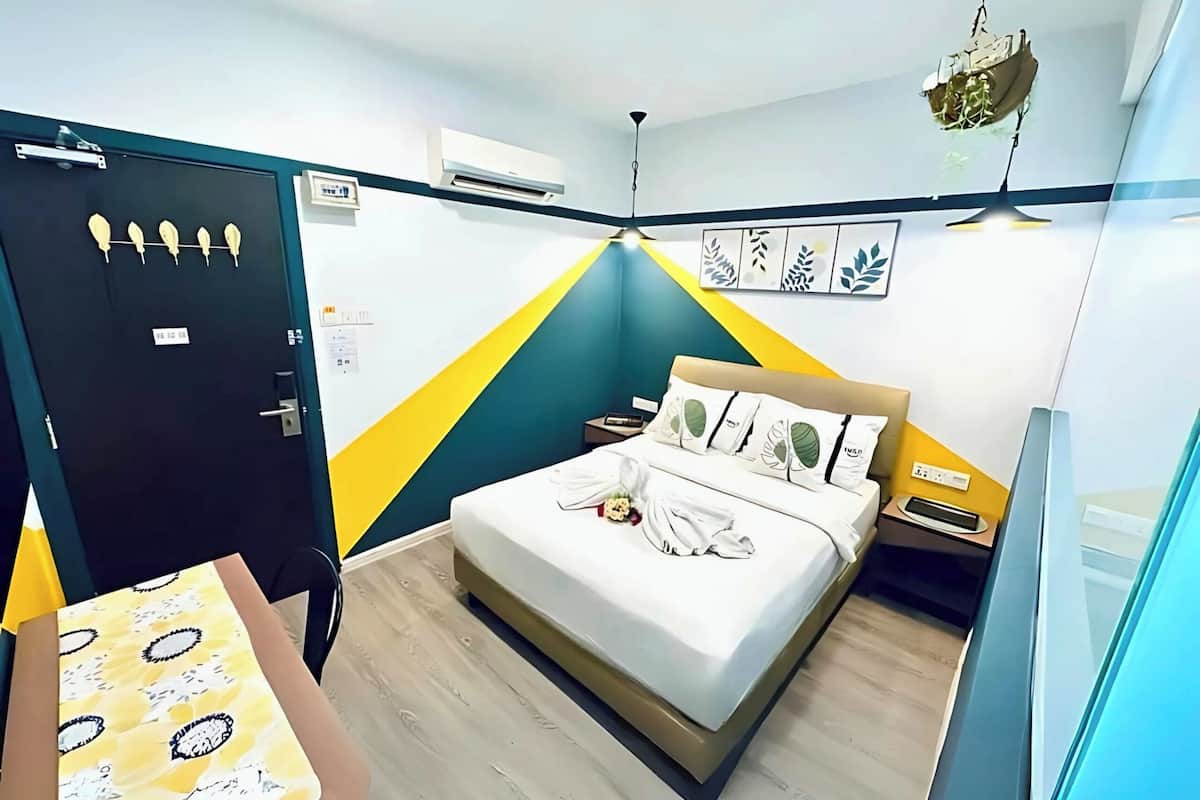 Quarto de hotel com cama, mesa de cabeceira, ar condicionado e porta.