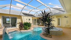 A swimming pool with a glass ceiling, surrounded by plants and a hot tub. - The Sandbar - 3BDR Courtyard Home w/Pool & Spa (Marco Island)