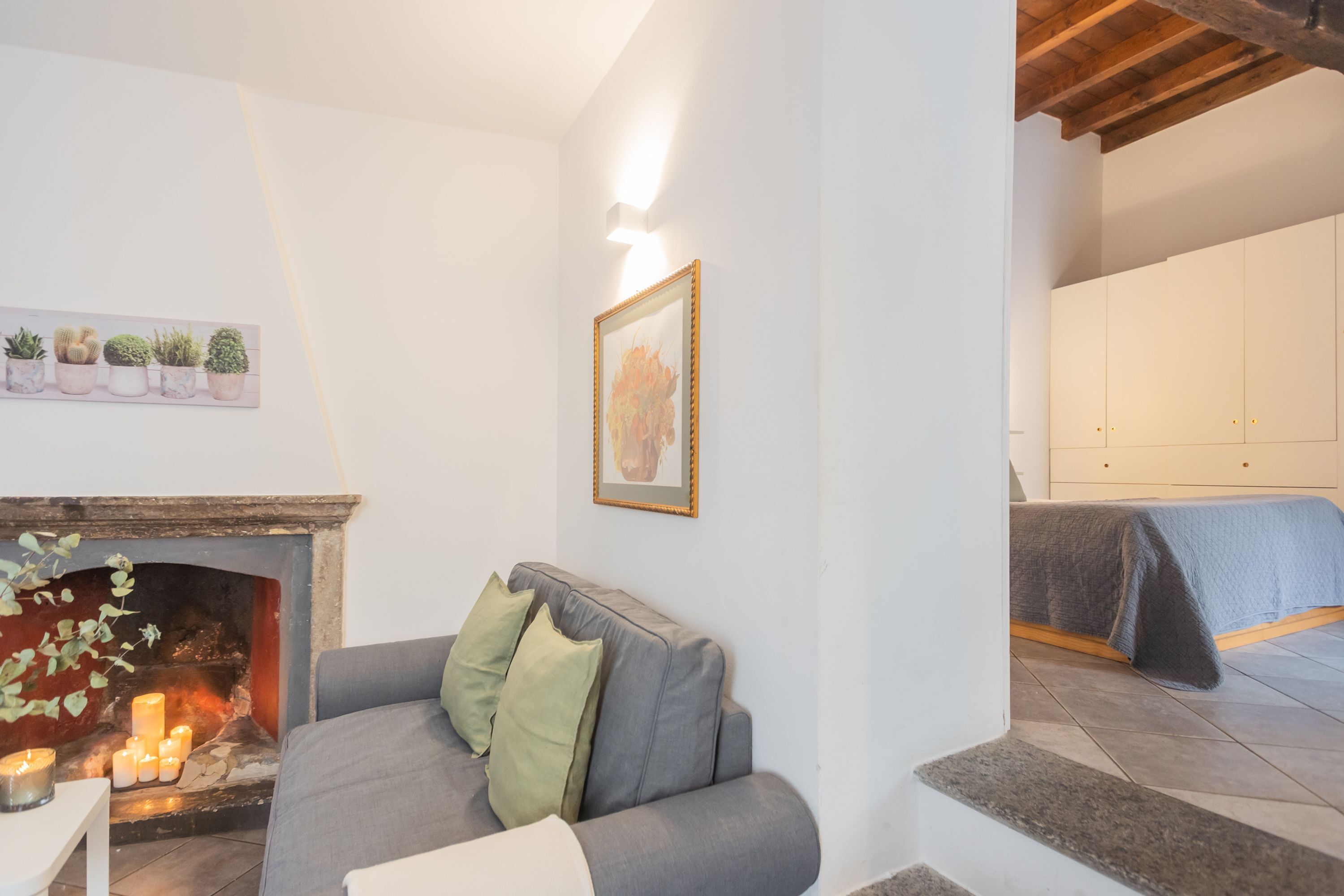 A living room with a fireplace, a sofa, and a bed.