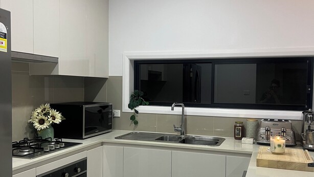 Una cucina moderna con forno integrato, microonde e lavello.