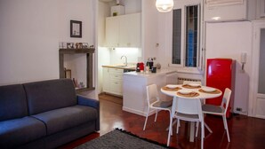 A compact living space with a kitchenette, a dining area, and a sofa. - Navigli Beautiful Apartment in MILAN Near TRAM (Milano)