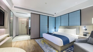 A modern hotel room with a large bed, a desk, and a seating area. - yishangchongzuohotel (Chongzuo)