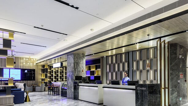 A modern hotel lobby with a reception desk, seating area, and a large column. - yishangchongzuohotel (Chongzuo)