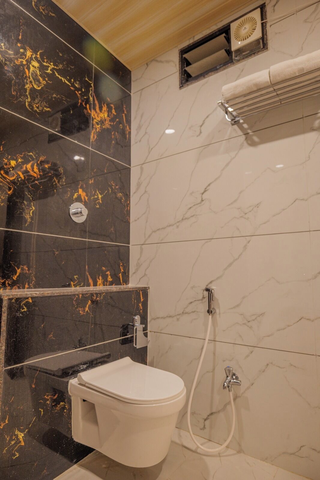 A bathroom with a toilet, a shower, and a towel rack.