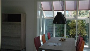 Un comedor con una mesa, sillas y una lámpara colgante.
