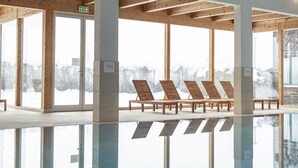 A modern indoor pool area with wooden beams, large windows, and sun loungers. - Traditional Chalet With Terrace (Sankt Georgen am Kreischberg)