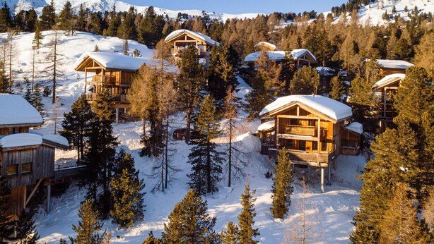 A snow-covered mountain lodge with multiple wooden cabins, surrounded by trees and a clear sky. - Chalet in Turracher Hohe Near Ski Slopes (Stadl-Predlitz)