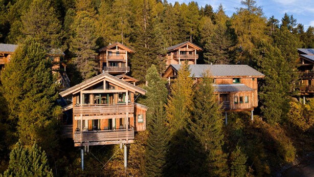 A wooden cabin complex with multiple levels, surrounded by dense forest. - Chalet in Austria Near Ski Slope & Sauna (Stadl-Predlitz)