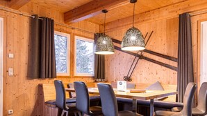 A wooden interior with a dining table, chairs, and pendant lights. - Chalet in Austria Near Ski Slope & Sauna (Stadl-Predlitz)